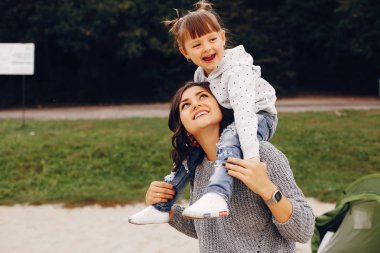 Anne ve kızı yaz parkında oynuyorlar.