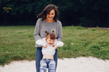 Anne ve kızı yaz parkında oynuyorlar.