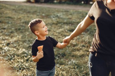 Anne ve oğlu yaz parkında oynuyorlar.