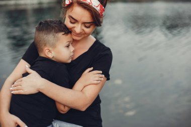 Anne ve oğlu yaz parkında oynuyorlar.