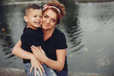 Anne ve oğlu yaz parkında oynuyorlar.