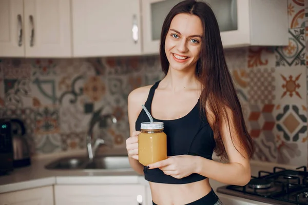 Sports girl in a kitchen with fruits