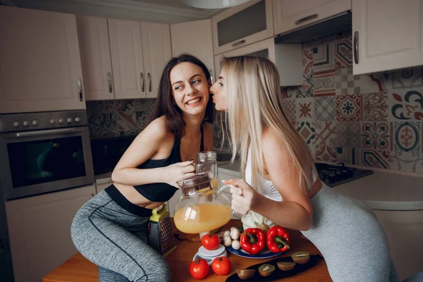 Dwa sportowe dziewczyna w kuchni z warzywami — Zdjęcie stockowe