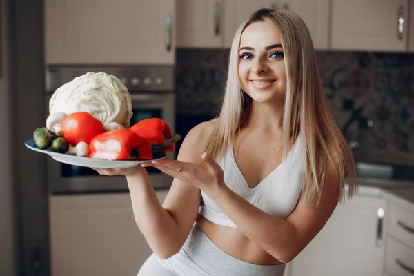 Sportovní dívka v kuchyni s ovocem — Stock fotografie