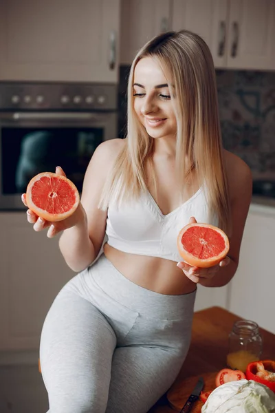 Chica deportiva en una cocina con frutas —  Fotos de Stock