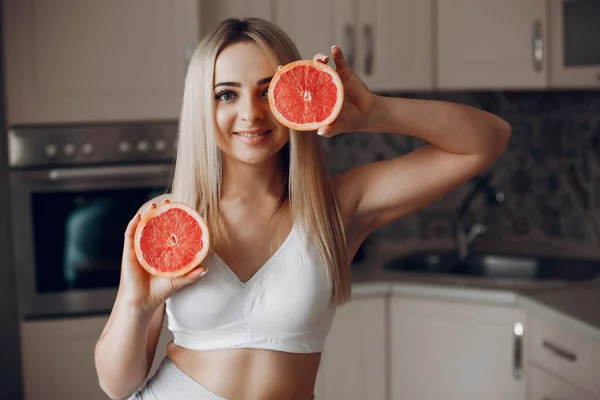 Sport fille dans une cuisine avec des fruits — Photo