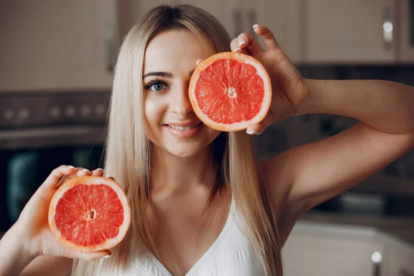 Sports girl in a kitchen with fruits