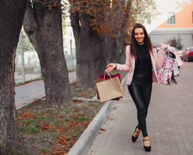 Şehirde alışveriş çantalı bir kadın.