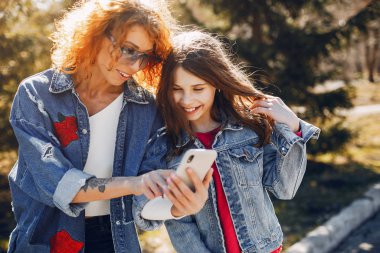 Bir yaz parkında kızı olan zarif bir anne.