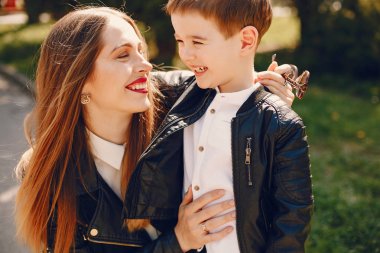 Anne ve oğlu yaz parkında oynuyorlar.