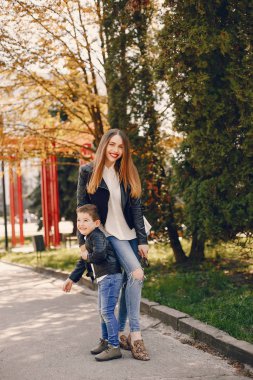 Anne ve oğlu yaz parkında oynuyorlar.