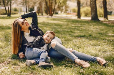 Anne ve oğlu yaz parkında oynuyorlar.