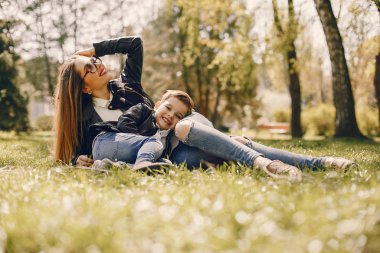 Anne ve oğlu yaz parkında oynuyorlar.