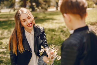 Anne ve oğlu yaz parkında oynuyorlar.