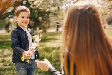 Anne ve oğlu yaz parkında oynuyorlar.