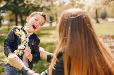 Anne ve oğlu yaz parkında oynuyorlar.
