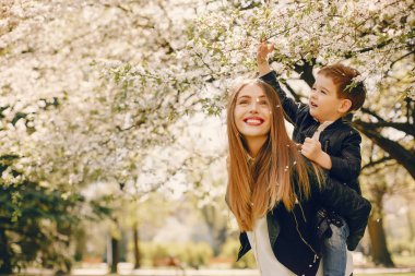 Anne ve oğlu yaz parkında oynuyorlar.