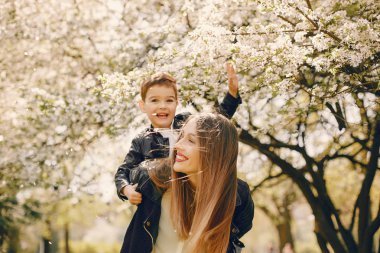 Anne ve oğlu yaz parkında oynuyorlar.