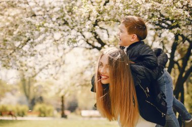 Anne ve oğlu yaz parkında oynuyorlar.