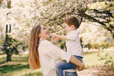 Anne ve oğlu yaz parkında oynuyorlar.
