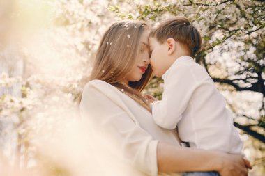 Anne ve oğlu yaz parkında oynuyorlar.