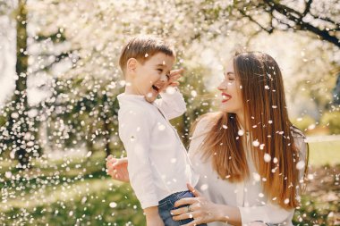 Anne ve oğlu yaz parkında oynuyorlar.