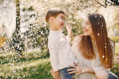 Anne ve oğlu yaz parkında oynuyorlar.