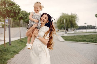 Anne ve kızı yaz parkında oynuyorlar.