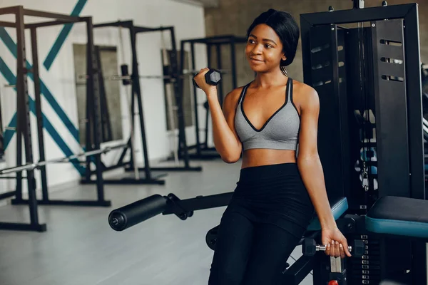 A beautiful black girl is engaged in a gym — Stock Photo, Image