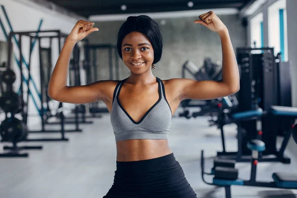 Una hermosa chica negra se dedica a un gimnasio — Foto de Stock