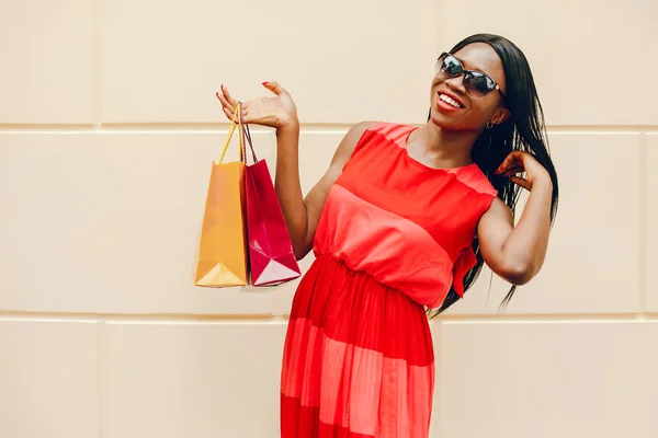 Belle fille noire avec des sacs à provisions dans une ville — Photo