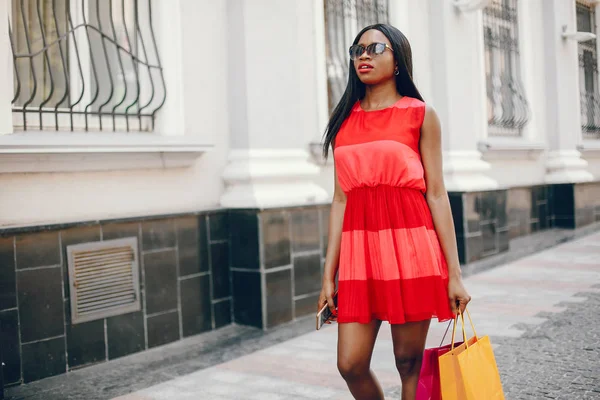Όμορφο μαύρο κορίτσι με σακούλες για ψώνια σε μια πόλη — Φωτογραφία Αρχείου