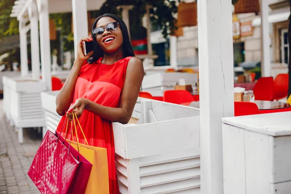 Menina preta bonita com sacos de compras em uma cidade — Fotografia de Stock