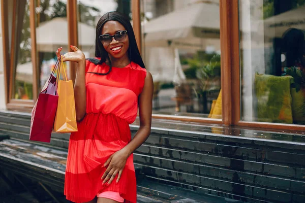 Gyönyörű fekete lány bevásárlótáskákkal a városban — Stock Fotó