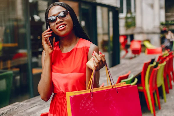 Schönes schwarzes Mädchen mit Einkaufstaschen in einer Stadt — Stockfoto
