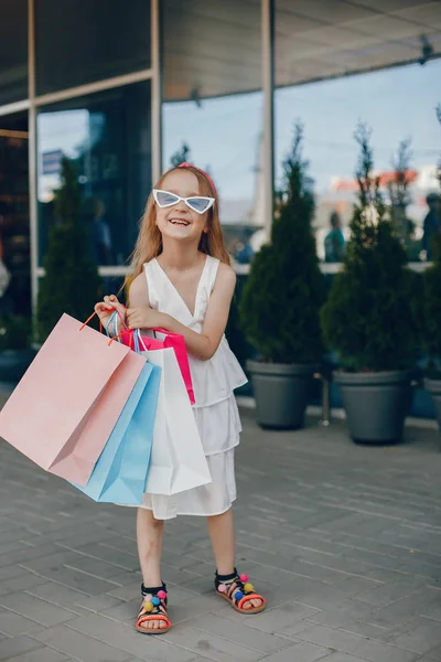 Χαριτωμένο μικρό κορίτσι με τσάντα για ψώνια σε μια πόλη — Φωτογραφία Αρχείου