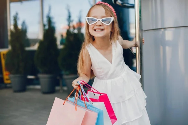 Χαριτωμένο μικρό κορίτσι με τσάντα για ψώνια σε μια πόλη — Φωτογραφία Αρχείου