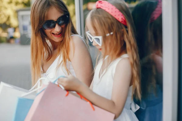 Moeder en dochter met boodschappentas in een stad — Stockfoto