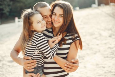 Kızı kumda oynayan aile