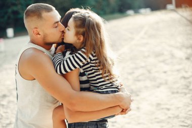 Kızı kumda oynayan aile