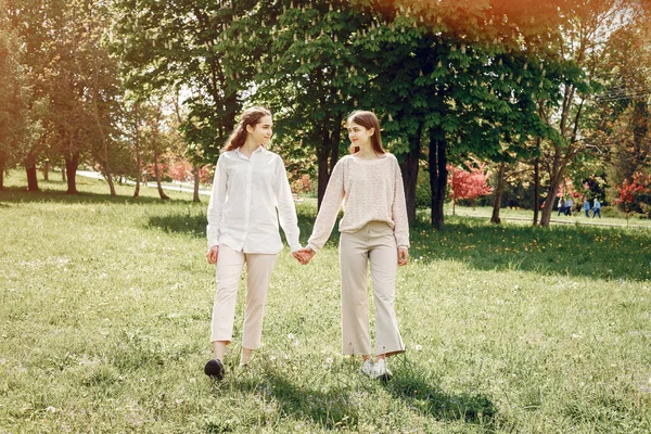 Irmãs elegantes e elegantes em um parque de primavera — Fotografia de Stock