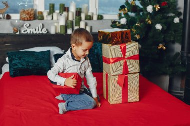 küçük çocuk Noel ağacının yanında oturan