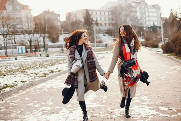 Zwei stylische Mädchen ruhen sich in einer Stadt aus — Stockfoto