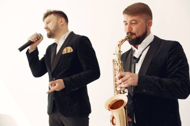 İki yetişkin müzisyen stüdyoda bekliyor.