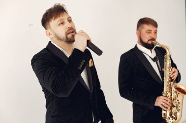 İki yetişkin müzisyen stüdyoda bekliyor.