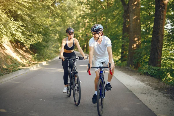 Spor çifti yaz ormanlarında bisiklet sürüyor.