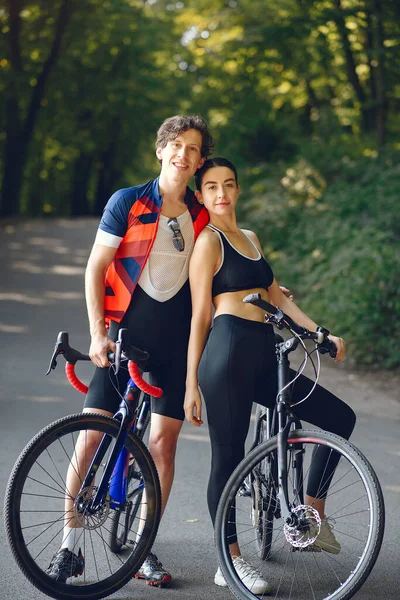 Deportes pareja montar en bicicleta en el bosque de verano — Foto de Stock