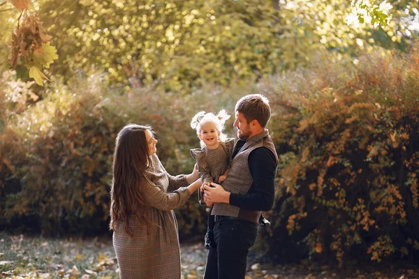 Family with little daughter in a autumn park — Stock Photo, Image