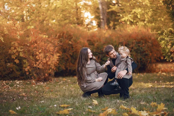 Família com pequena filha em um parque de outono — Fotografia de Stock