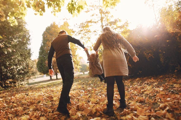 Família com pequena filha em um parque de outono — Fotografia de Stock